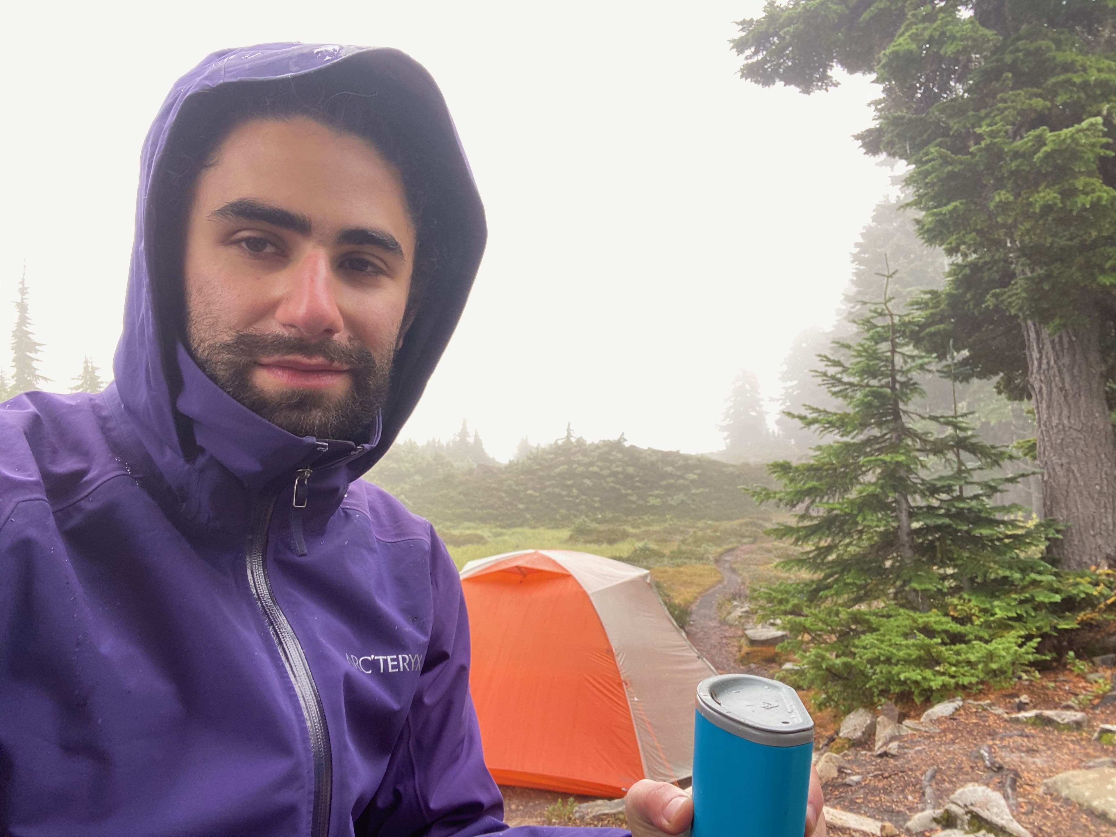 grimacing in the rain while backpacking